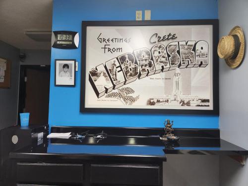 a picture hanging on a blue wall above a sink at Super Star Inn & Suite Lincoln Crete in Crete