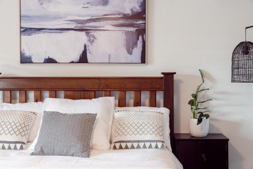 a bedroom with a bed with pillows and a painting at Roo With A View By Swan Bnb Management in Preston Beach