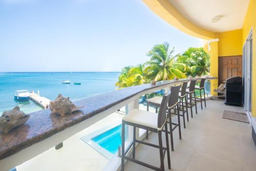 a bar on the balcony of a resort with the ocean at Del Playa #3 Condo in West End