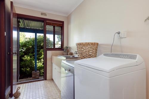 a kitchen with a washing machine and a window at Roo With A View By Swan Bnb Management in Preston Beach