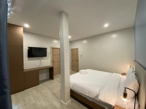 a bedroom with a bed and a flat screen tv at The European Chiang Mai in Chiang Mai