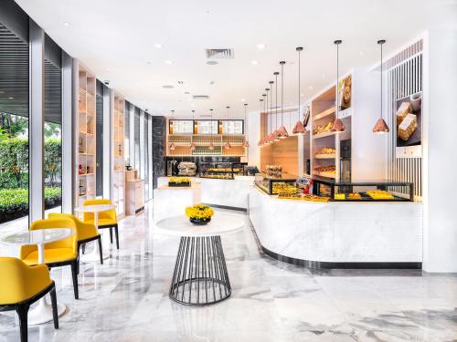 a restaurant with yellow chairs and tables at Four Seasons Hotel Guangzhou - Free Shuttle Bus to Canton Fair Complex & Overseas Buyer Registration Services during Canton Fair Period in Guangzhou