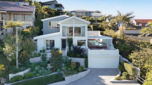 a house on the hill with a garden at The Lookout Lounge - Pet Friendly, Pool, Great Views! in Coffs Harbour