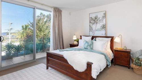 a bedroom with a bed and a large window at The Lookout Lounge - Pet Friendly, Pool, Great Views! in Coffs Harbour