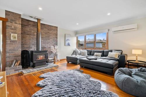 a living room with a couch and a fireplace at Beach Holiday Home-Close to Airport-3 Bed & 2 Bath in Lauderdale