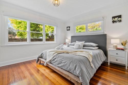 a white bedroom with a bed and windows at Beach Holiday Home-Close to Airport-3 Bed & 2 Bath in Lauderdale