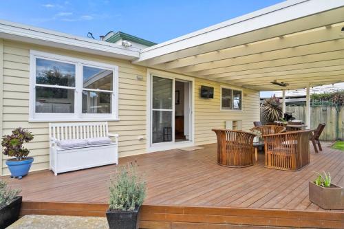 a wooden deck with chairs and a table at Beach Holiday Home-Close to Airport-3 Bed & 2 Bath in Lauderdale