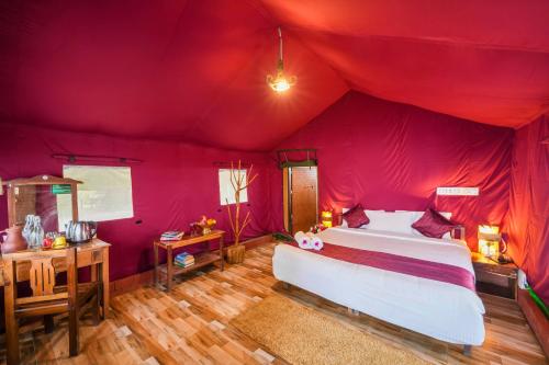 a bedroom with a bed in a red tent at Nature Zone Jungle Resort in Munnar