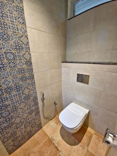 a bathroom with a toilet and a tiled wall at Tathastu Tadoba in Mohurli