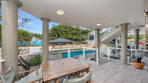 a patio with a table and a swimming pool at Stunning Ocean Views in Arcadia