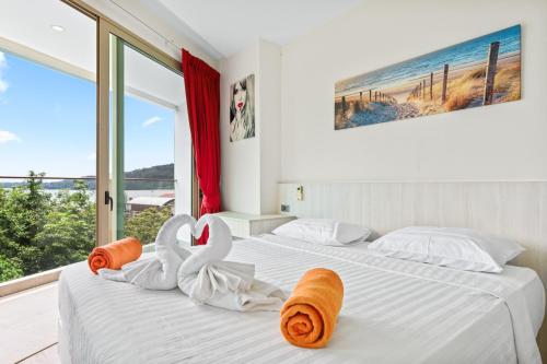 two beds in a room with a large window at Oceana Sea View Apartments - Kamala Beach in Kamala Beach