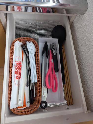 a drawer filled with utensils on a shelf at 海辺の宿錦 b in Tomakomai
