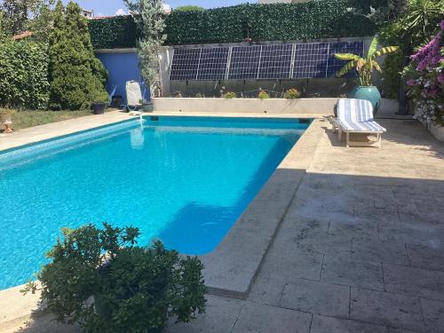 - une piscine avec une chaise dans la cour dans l'établissement Clos Des Vignes, à Mandelieu-la-Napoule