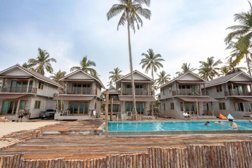a view of a resort with a pool and palm trees at Laemsui Beach แหลมซุย บีช in Ban Laem Sui