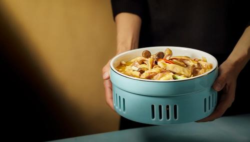 a person is holding a bowl of food at Shangri-La Nanning - The tallest hotel worldwide in Shangri-La Group in Nanning