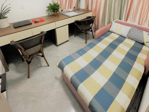 Un dormitorio con una cama y un escritorio y sillas. en Tao's Inn Guiyang, en Longli