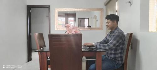 a man sitting at a table using a computer at Esmeralda in Querétaro