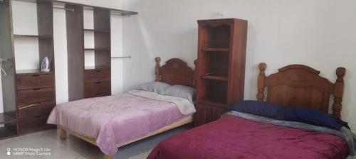 a bedroom with two beds and a dresser at Esmeralda in Querétaro