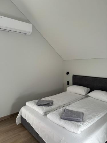 a bedroom with a bed with two towels on it at Kotedžas su dviem miegamaisiais in Palanga