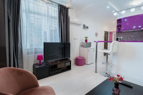 a living room with a tv and a chair at Ultra Central White & Lila Studio in Bucharest