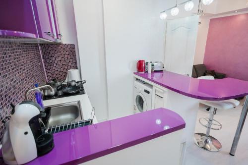 a purple counter top in a kitchen with a sink at Ultra Central White & Lila Studio in Bucharest