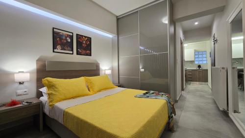 a bedroom with a yellow bed and a bathroom at Epsilon - Premier Apartment & Easy Parking by Optimum Link in Katerini