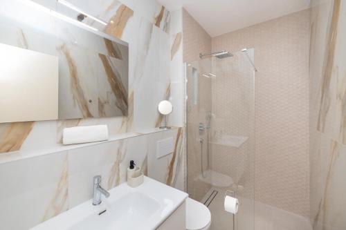 Un baño blanco con lavabo y ducha. en Familiy Villa Navis with heated pool, en Rogotin