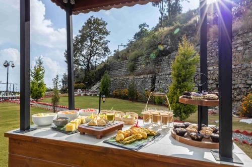 a buffet with food on a table with a mountain at amã Stays & Trails Barefoot Bungalow, Dhanaulti in Dhanaulti