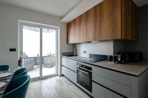 a kitchen with wooden cabinets and a large window at Luxury 2BR Maisonette in Sliema Private Hot Tub in Sliema