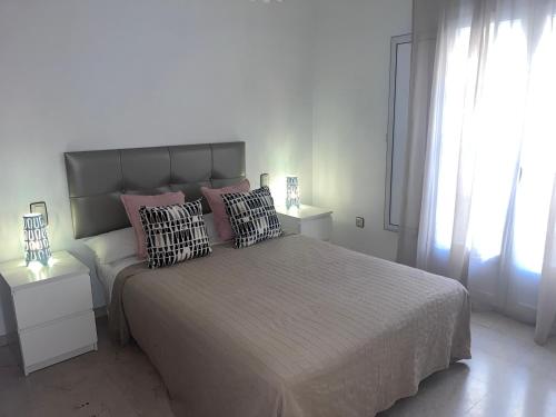 a bedroom with a large bed with pillows on it at Perla en el Corazón de Málaga in Málaga