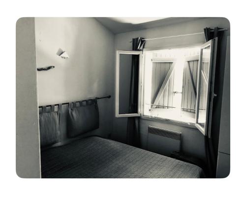 Cette petite chambre dispose d'une fenêtre et d'un lit. dans l'établissement Résidence la Pinède, à Sainte-Maxime