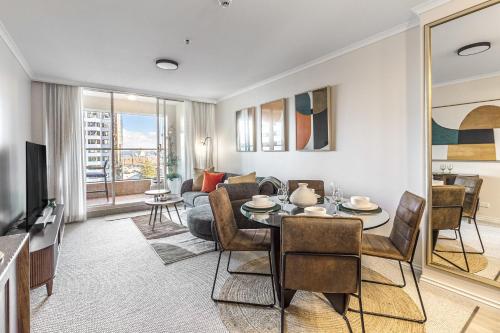 a living room with a dining room table and a couch at Luxurious Harbour View Apartment in Downtown in Auckland