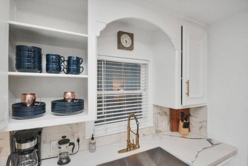 a kitchen with white cabinets and a sink and a window at Casa Hosum - 7 mins Downtown Sleeps 9 King Bed Fenced Yard in Houston