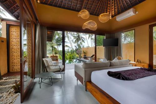 a bedroom with a large bed and a living room at Samkhya Villas - Free 1x Floating Breakfast or Minibar in Ubud