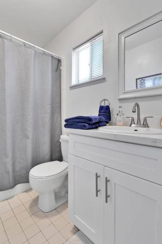 a white bathroom with a toilet and a sink at Oasis Condo on the Fairway in Victorville