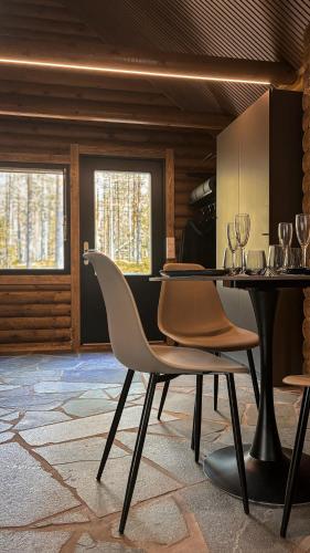 a dining room with a table with chairs and wine glasses at Sky Lodging ~ sleeping under the stars in Rovaniemi