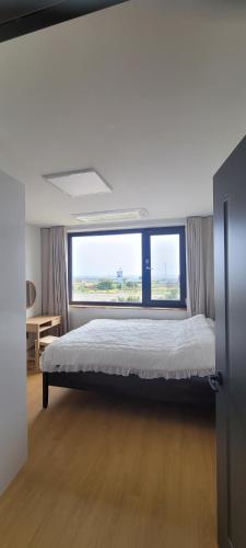Кровать или кровати в номере Jeju Paradise House