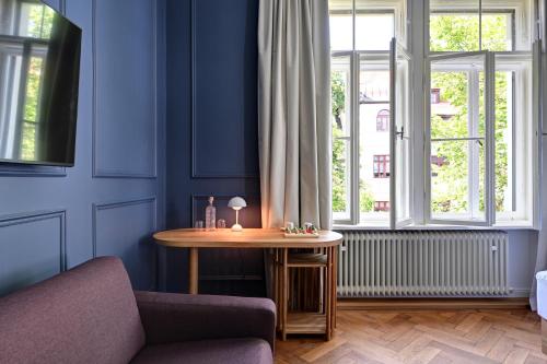 a blue room with a table in front of a window at Hotel Uhland in Munich