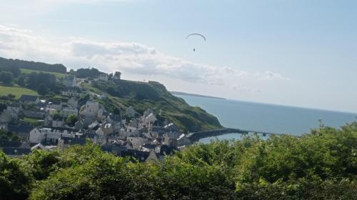 a small town on a hill next to the ocean at Logis proche des plages du débarquement in Vaucelles