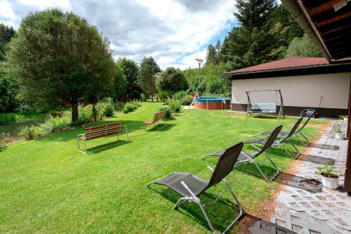 a group of chairs sitting on the grass in a yard at Penzion U rybníka in Šumperk