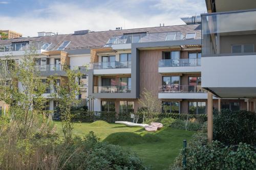 an apartment building with a green yard in front of it at Rezydencja Merwede Aparthotel - My Rest in Gdańsk