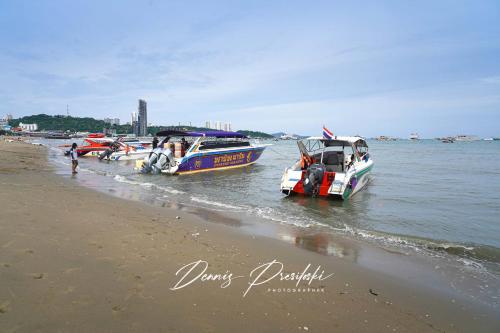 two boats parked on the shore of a beach at Luxury Edge Seaview Apartment in Pattaya Central