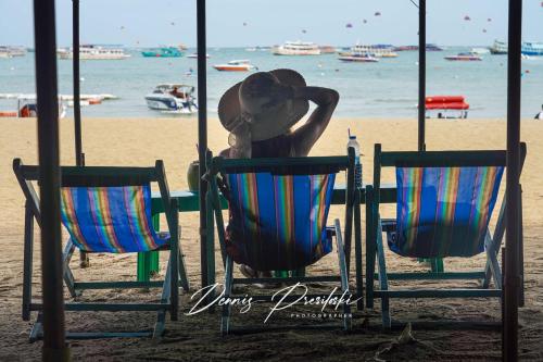 a person sitting in a chair on the beach at Luxury Edge Seaview Apartment in Pattaya Central