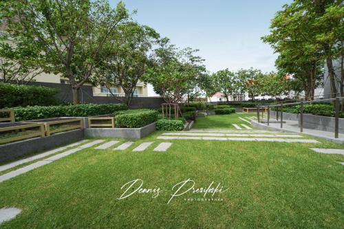 a park with grass and trees and a fence at Luxury Edge Seaview Apartment in Pattaya Central