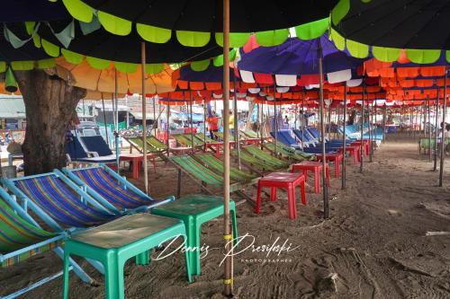 a group of chairs and umbrellas on a beach at Luxury Edge Seaview Apartment in Pattaya Central