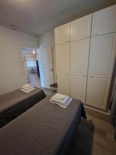 a bedroom with two beds and white cabinets at Kotareitti Apartments in Rovaniemi