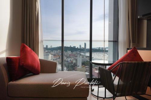 a living room with a couch and a large window at Luxury Edge Seaview Apartment in Pattaya Central