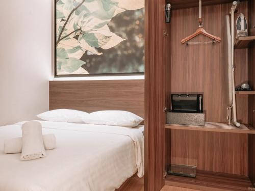 a hotel room with a bed and a tv at A Hotel Bugis in Singapore