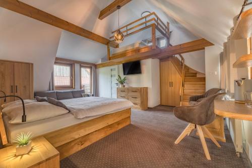 a bedroom with a bed and a desk with a chair at Penzión Michal in Ždiar