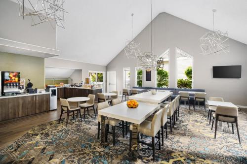 a dining room with tables and chairs and a kitchen at Residence Inn by Marriott Seattle/Bellevue in Bellevue